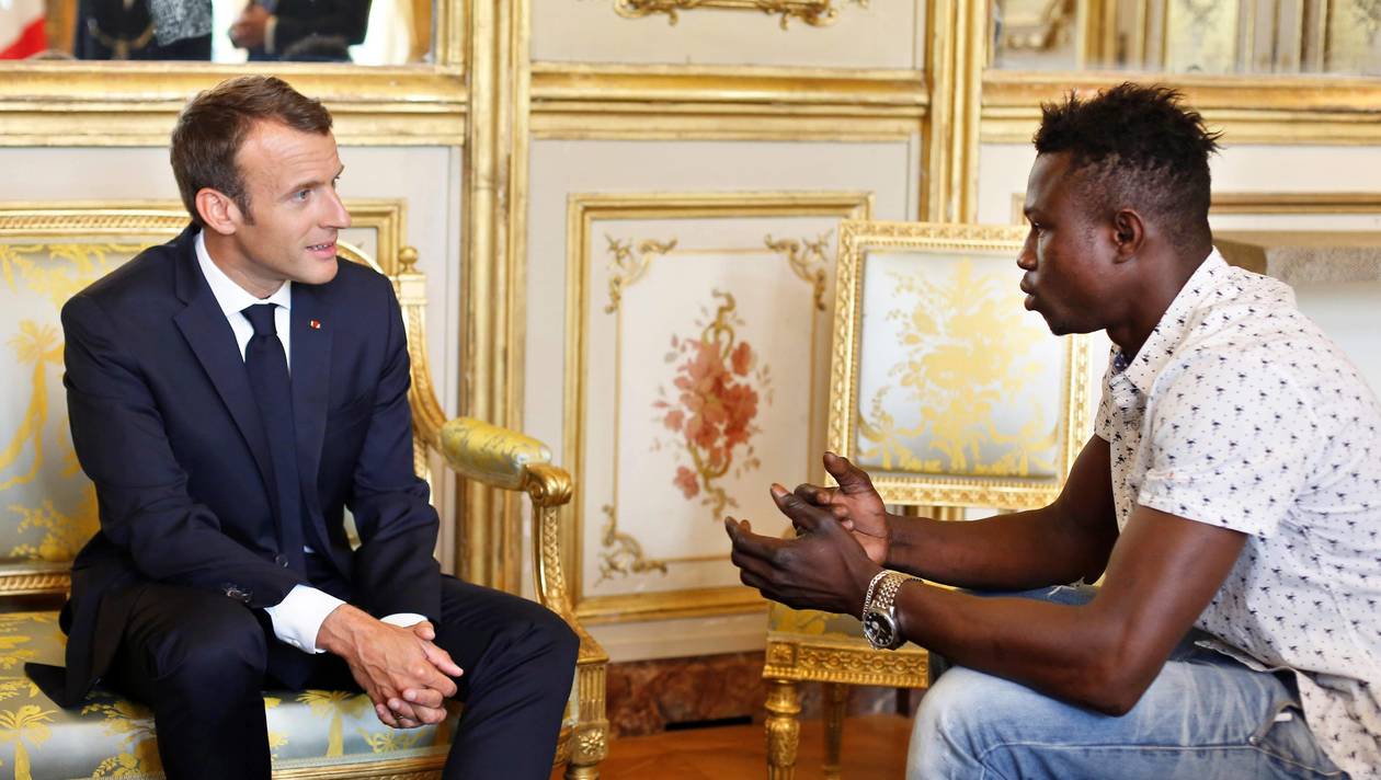 French President Emmanuel Macron (L) speaks with Mamoudou Gassama, 22, from Mali, at the presidential Elysee Palace in Paris, on May, 28, 2018. Mamoudou Gassama living illegally in France is being honored by Macron for scaling an apartment building over the weekend to save a 4-year-old child dangling from a fifth-floor balcony.