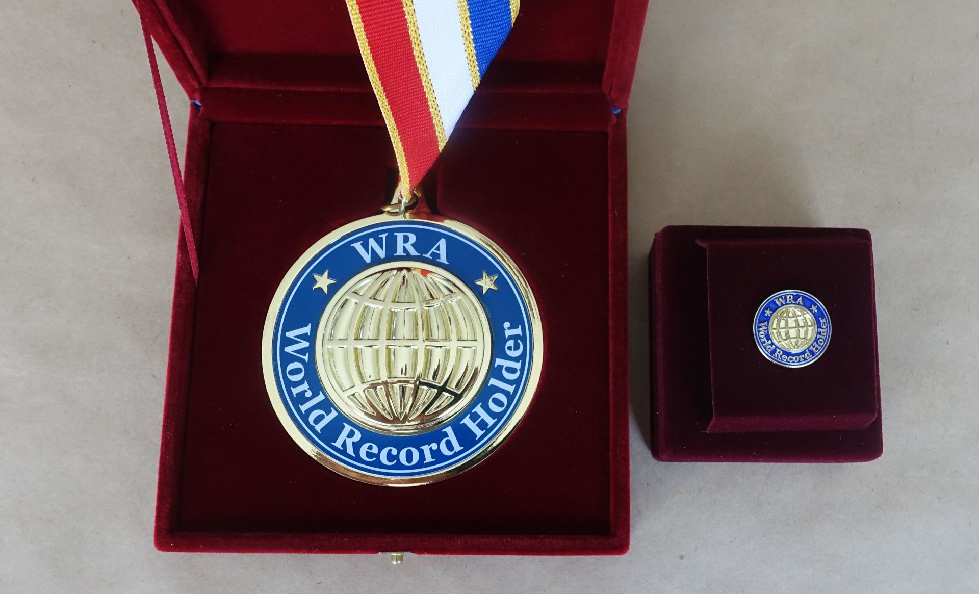   World Record Holder Medal & World Record Holder Pin for Mrs. Suzy Seeley, the new record holder for the Most Marathons Run Under Four Hours  (Female). Photo: AOWR