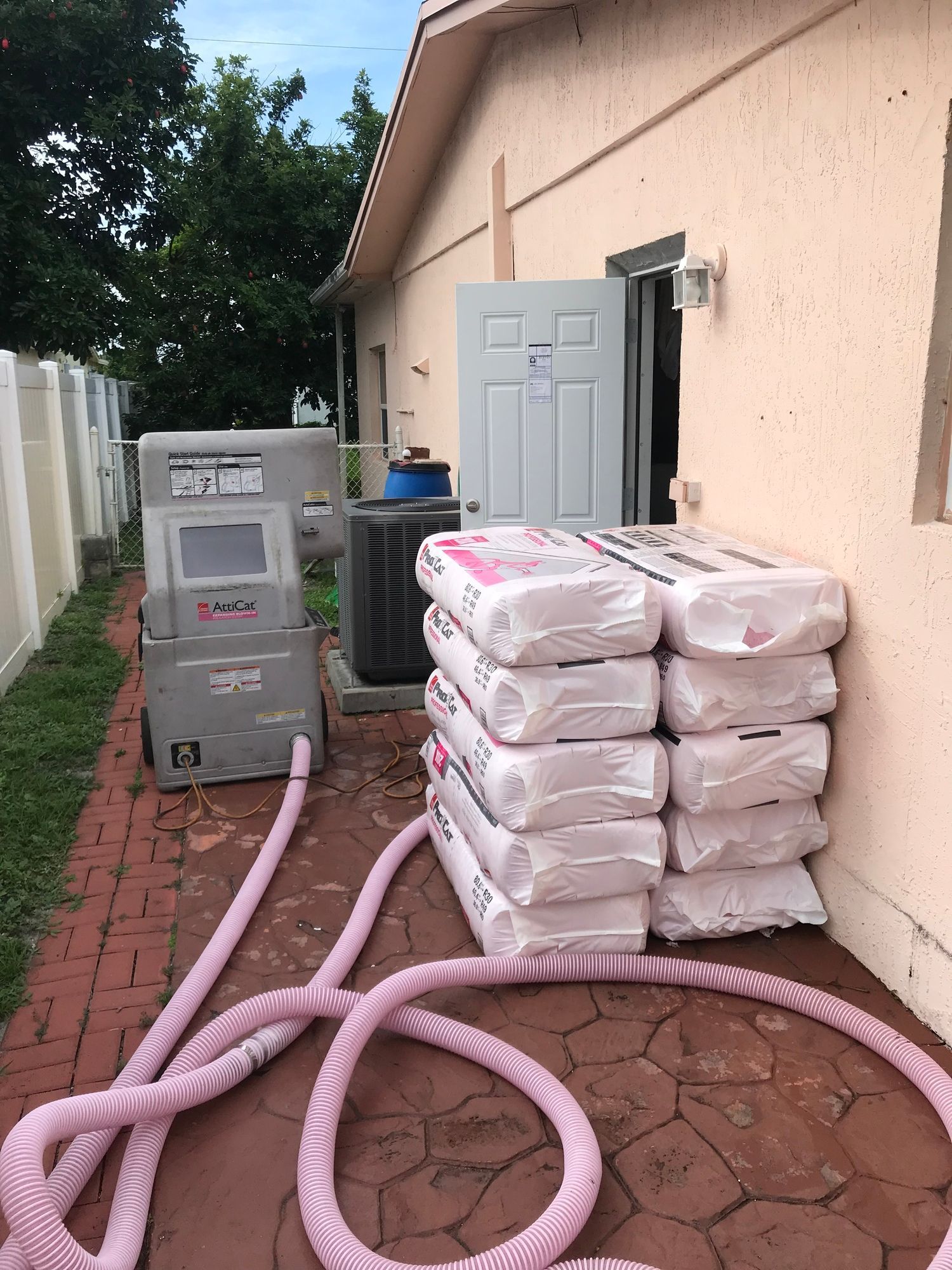 A stack of bags of insulation is sitting on the side of a house.