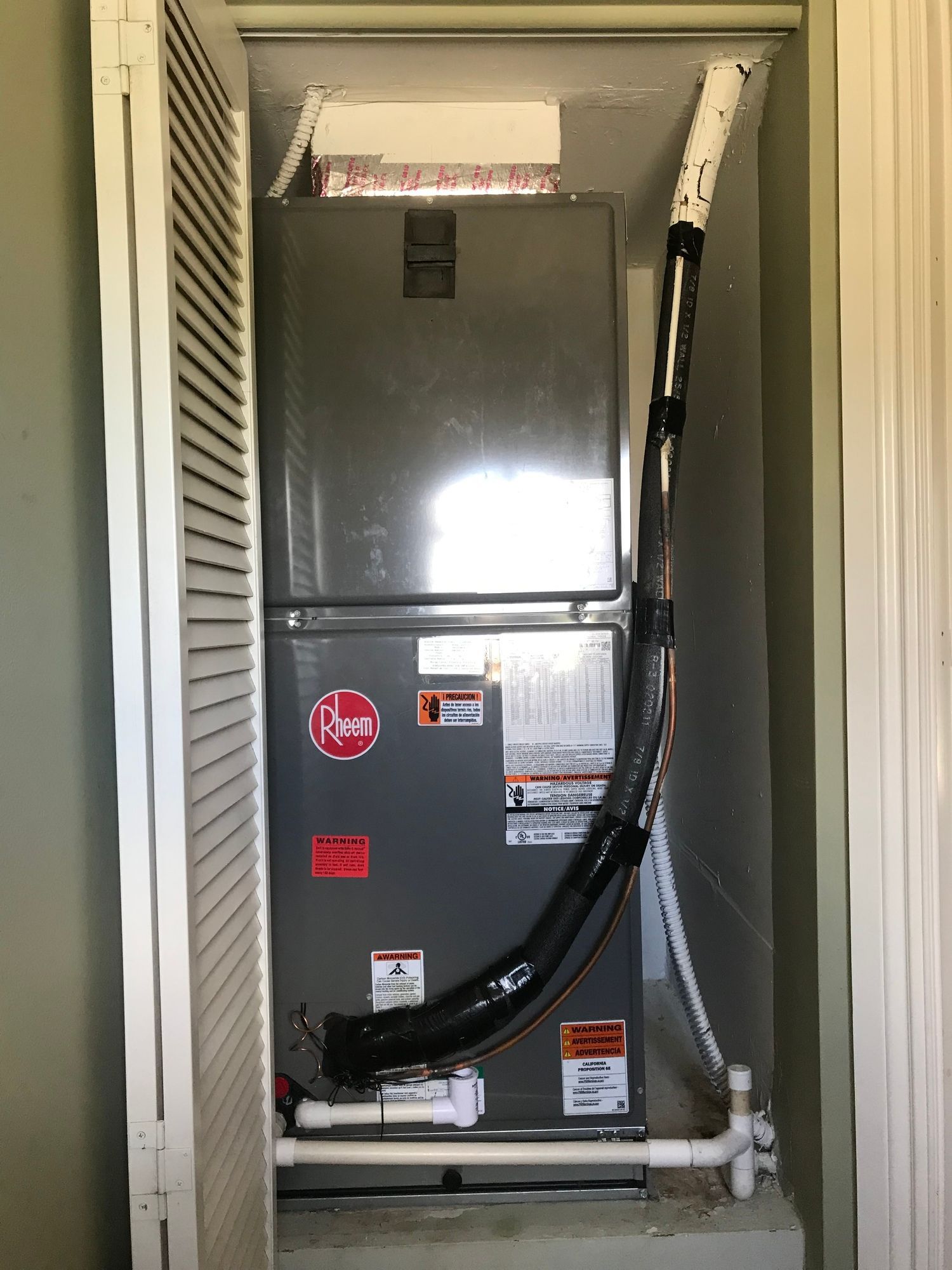 An air conditioner is sitting inside of a closet.