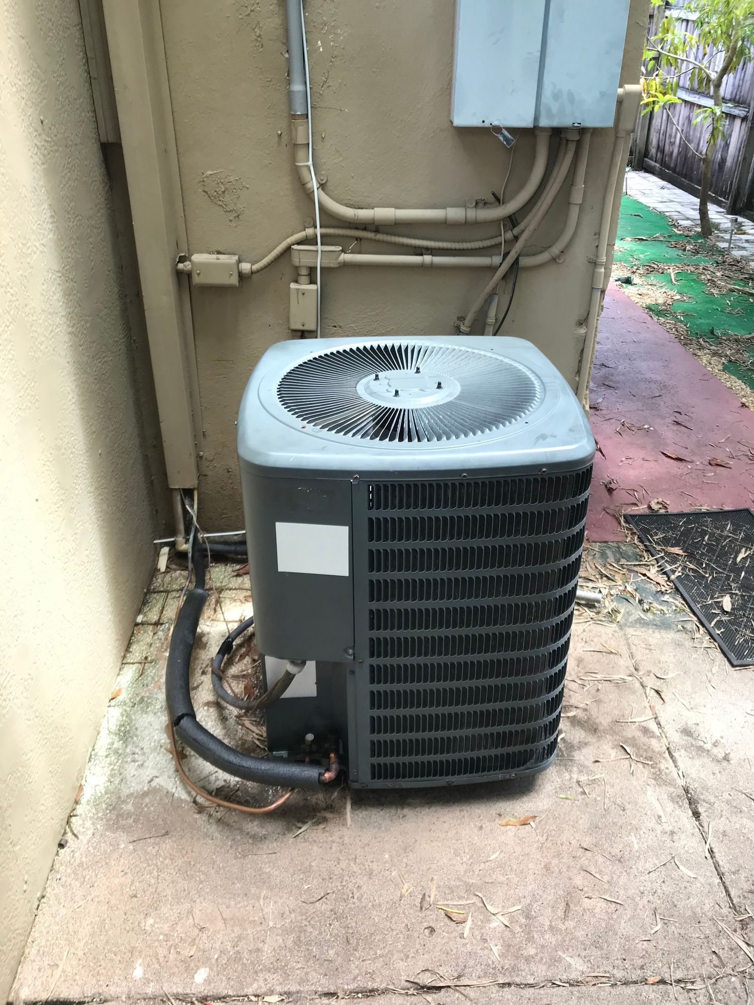An air conditioner is sitting on the side of a building.