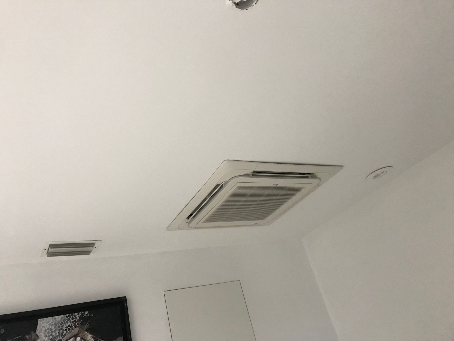 A room with a ceiling fan and a picture on the wall.