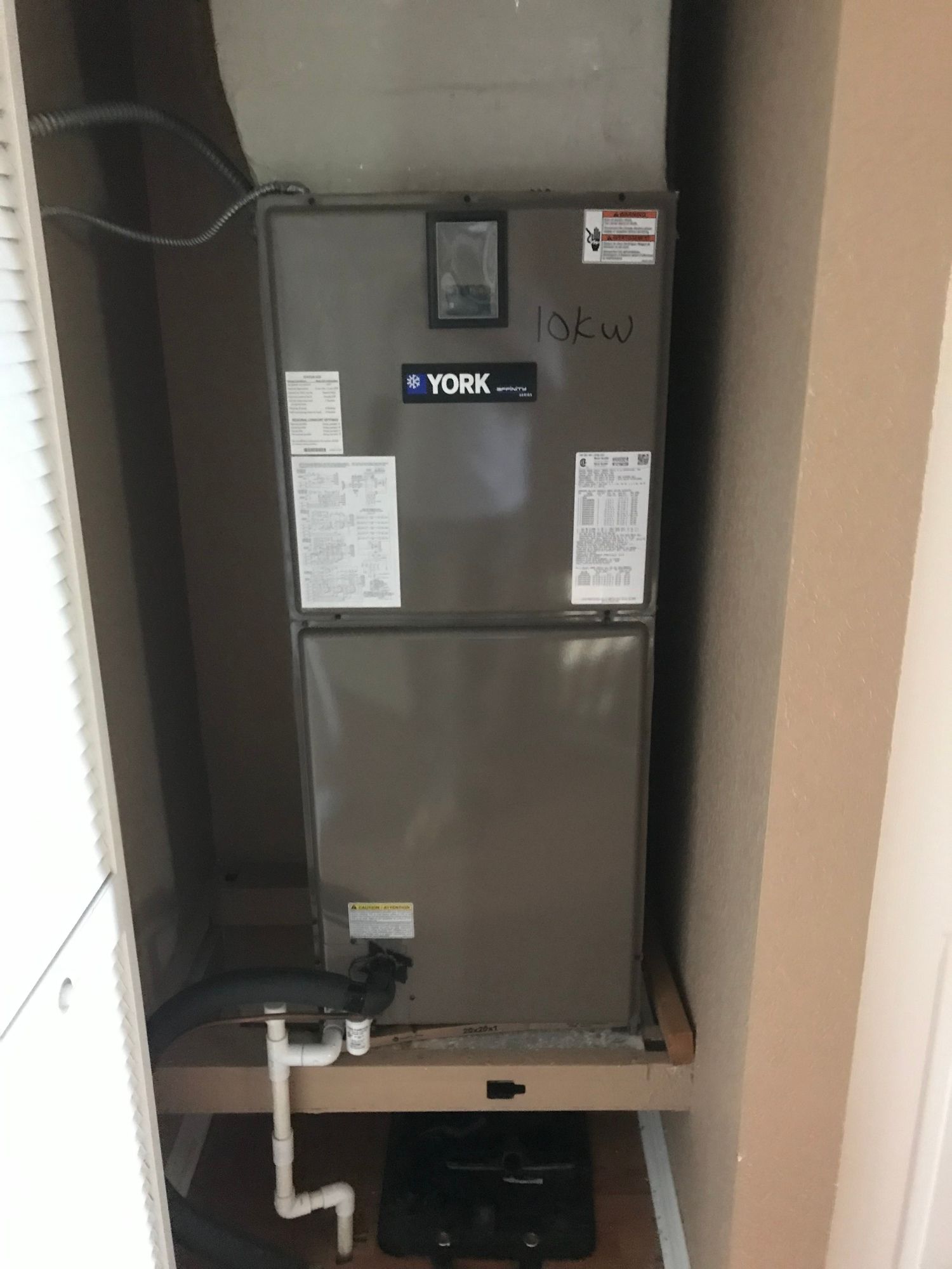 A york air conditioner is sitting in a closet.