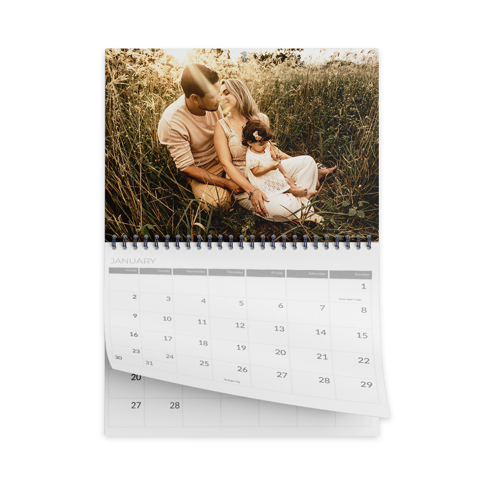 Calendrier présentant une famille de trois personnes dans un champ, avec une photo en haut et une grille de calendrier en dessous.