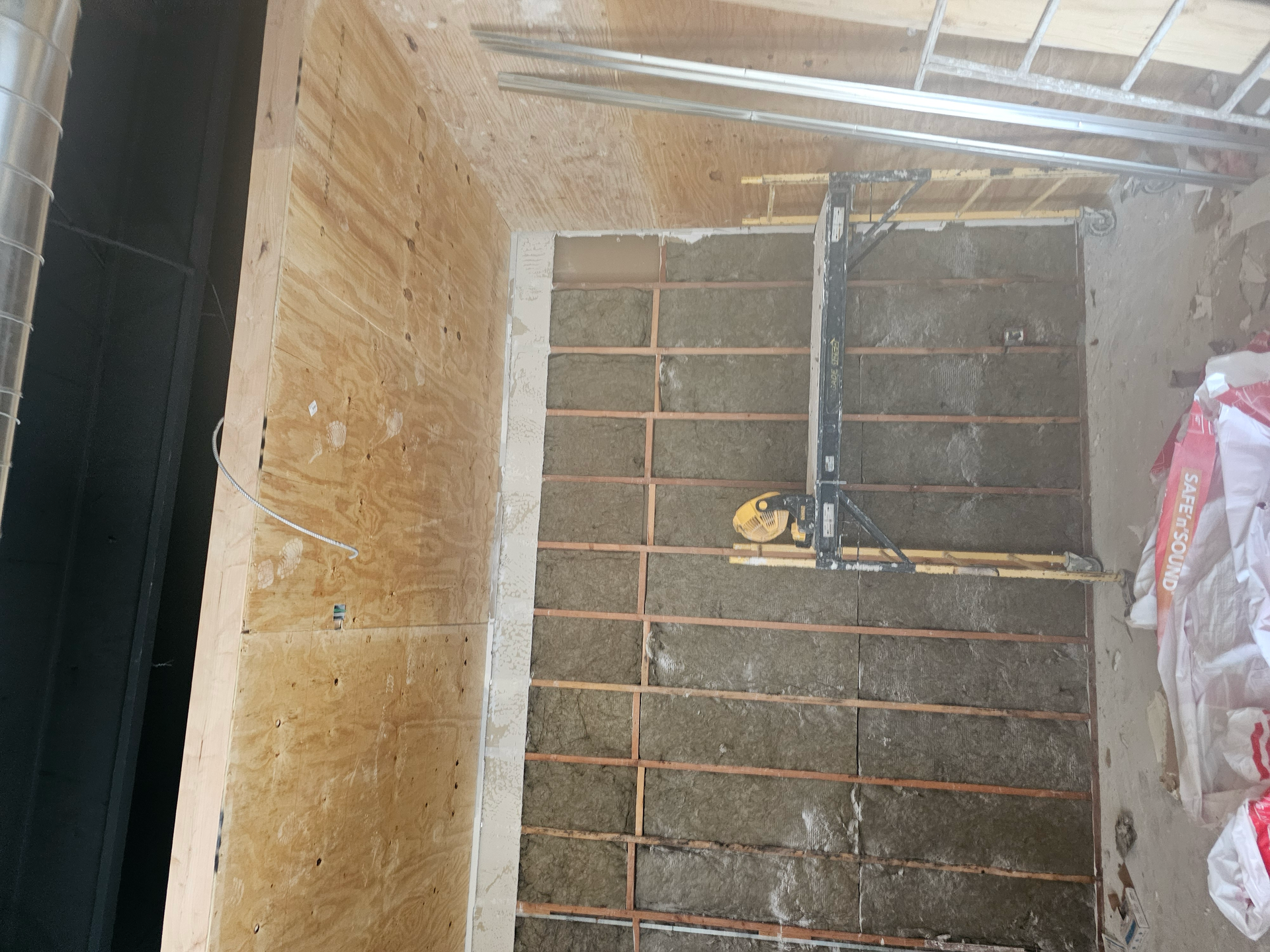 A room with a brick wall and a ladder in it