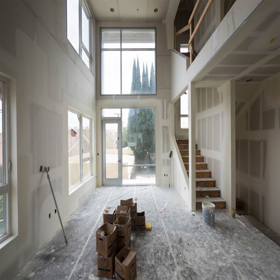 An empty room with a lot of windows and boxes on the floor