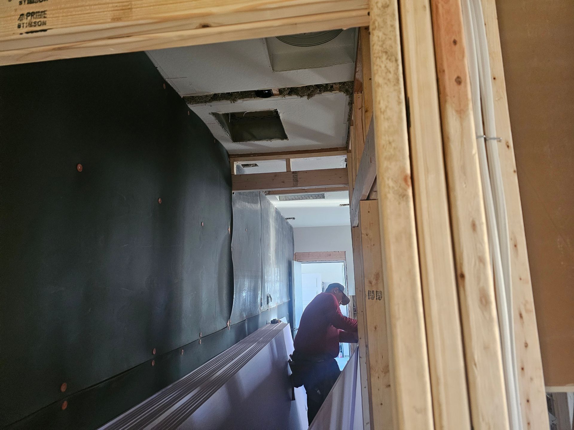 A man is working on a wall in a building under construction.