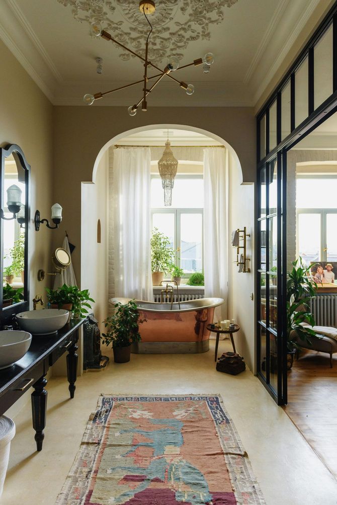 A bathroom with a bathtub , sinks , mirrors and a rug.