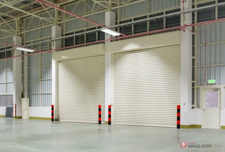 A warehouse with two rolling shutters on the side of the building. contact us Smart Garage Door Service