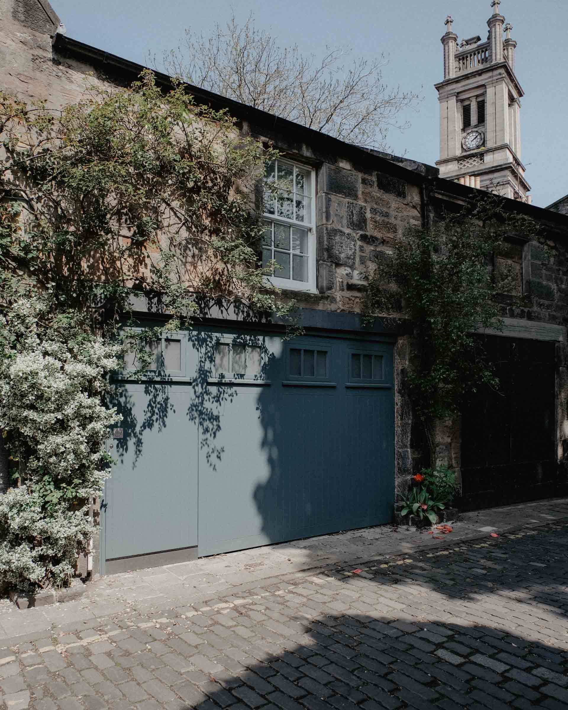 A brick building with a blue garage door and a clock tower in the background Metal Garage Doors Smart Garage Door Service
