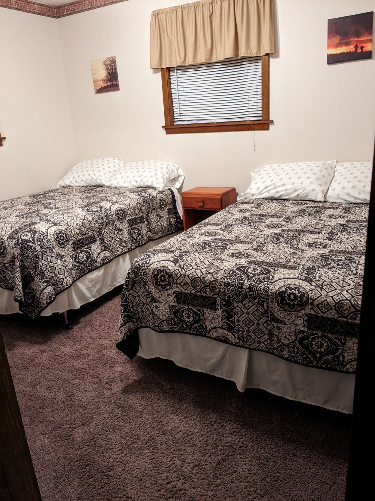 A bedroom with two beds and a window