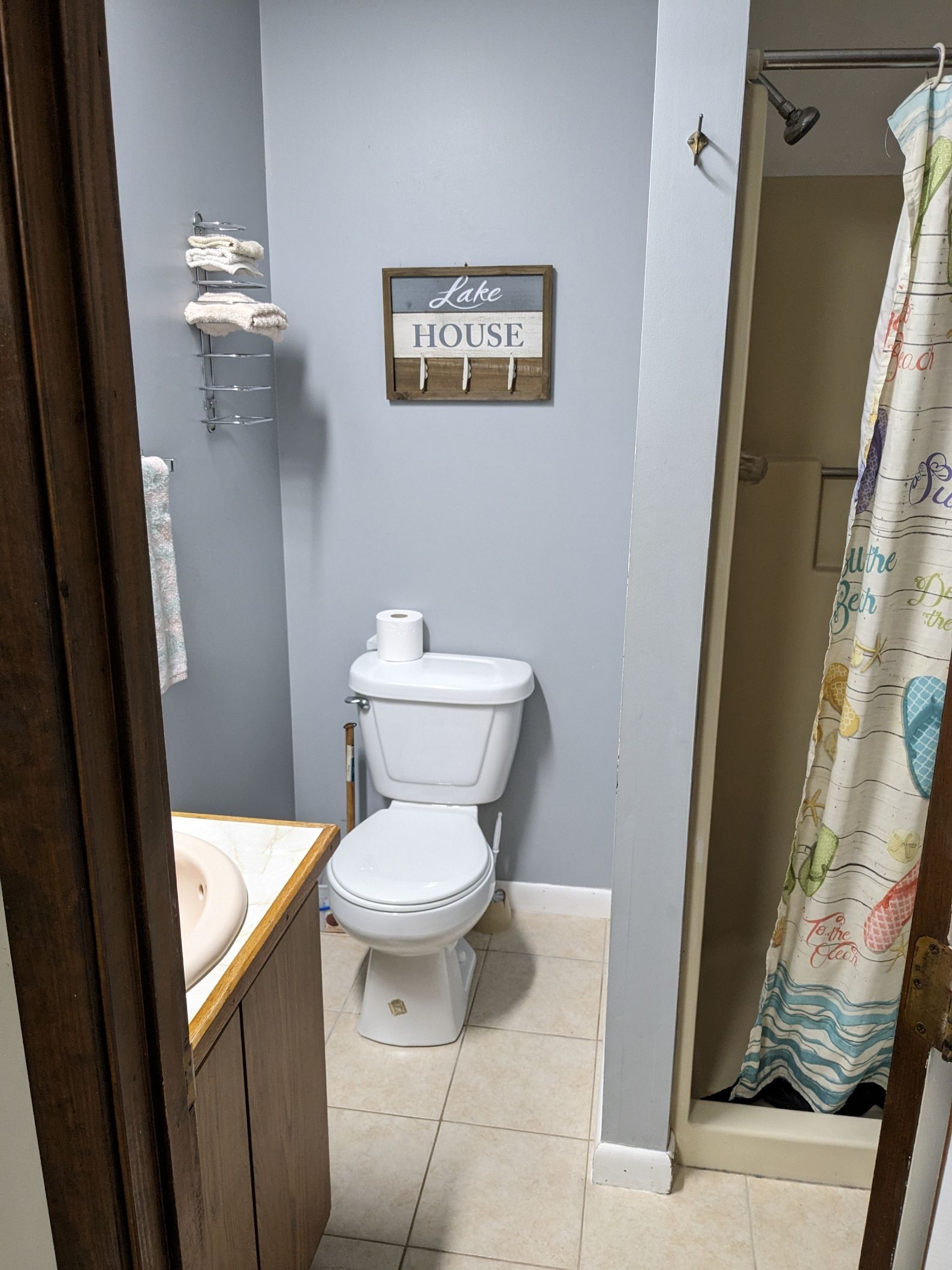 A bathroom with a toilet , sink and shower.