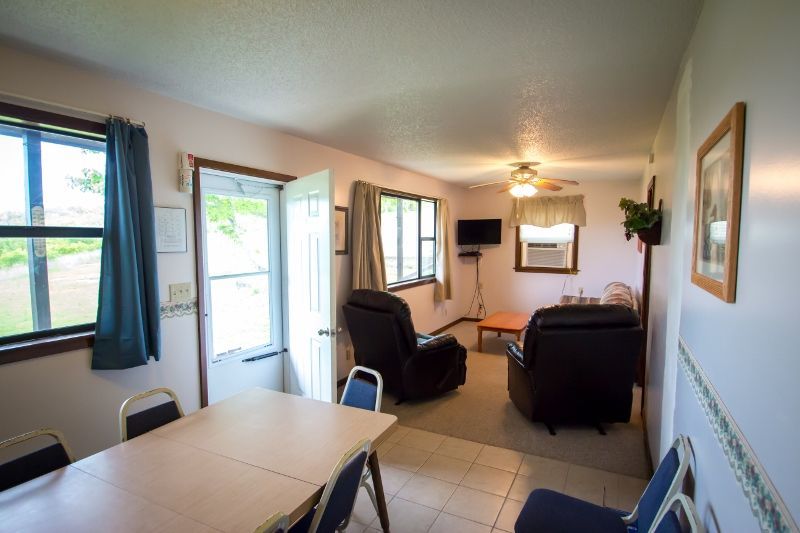 A living room with a table , chairs , and a television.