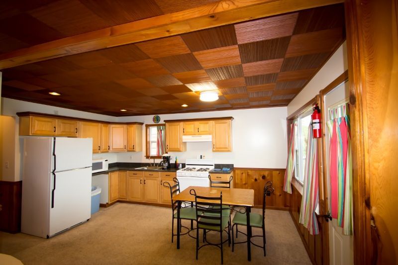 A kitchen with a table and chairs and a refrigerator