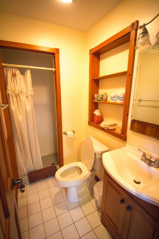 A bathroom with a toilet a sink and a shower