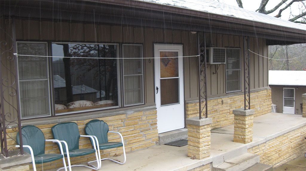 A house with a porch and chairs in front of it