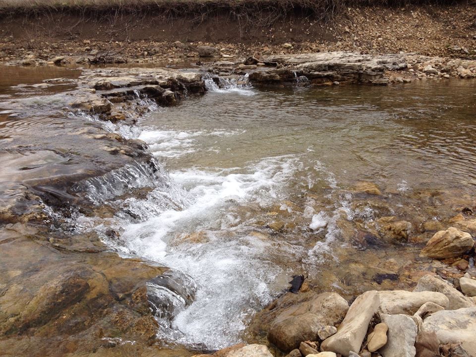 A river flowing through a rocky area with a small waterfall