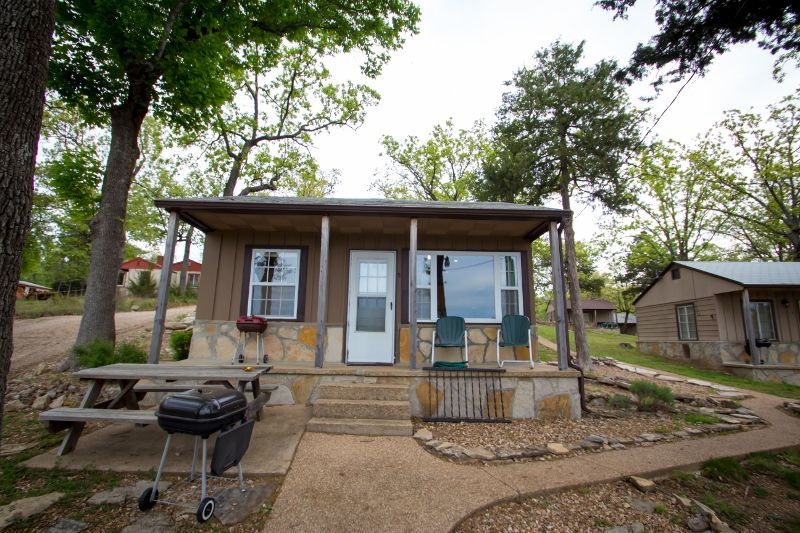 A small house with a porch and a picnic table