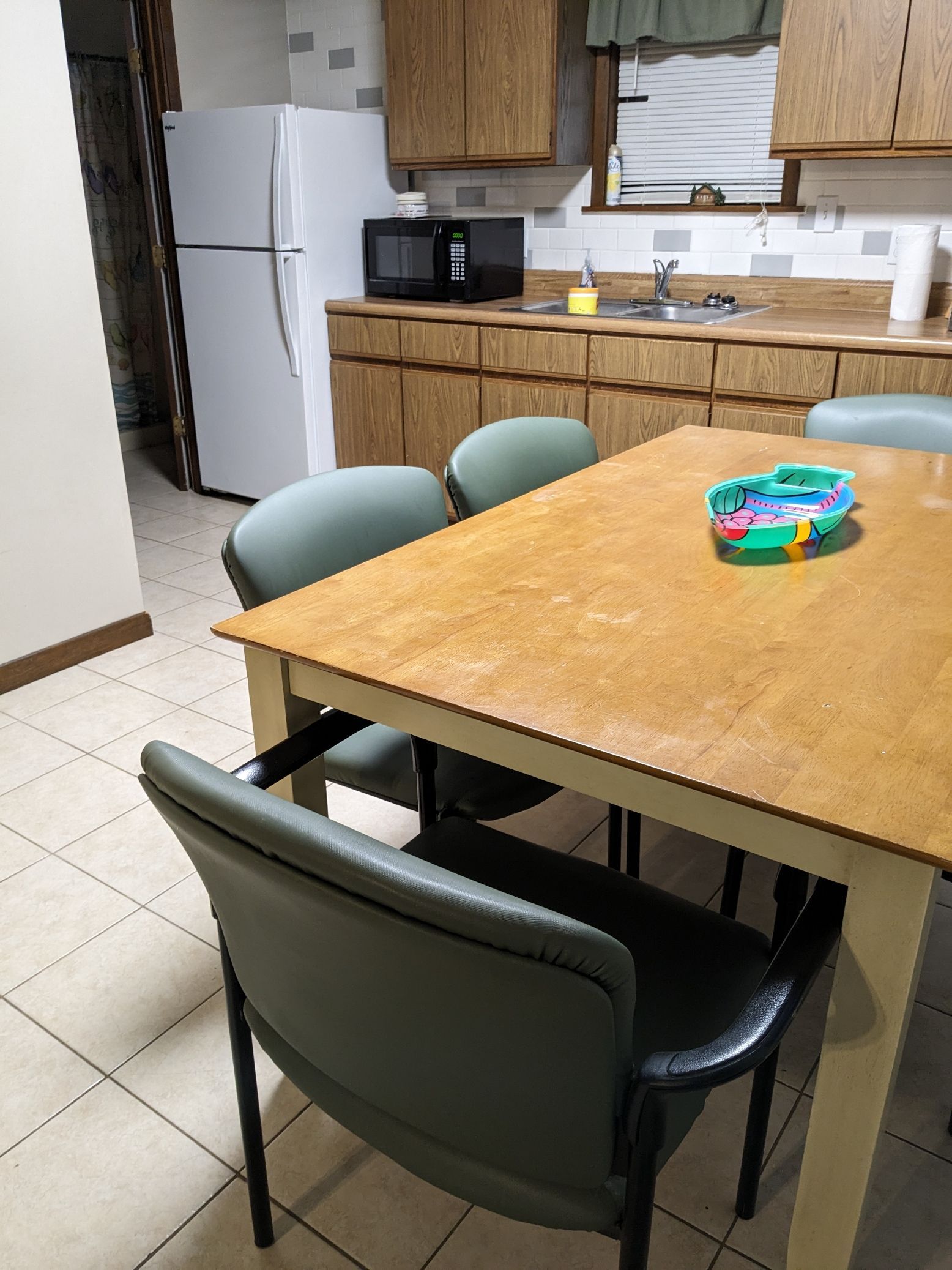 A kitchen with a table and chairs and a refrigerator