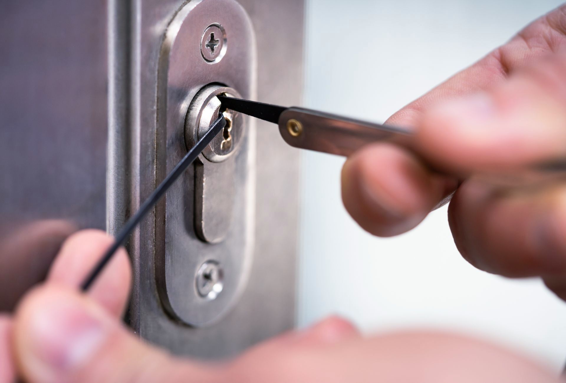 A person is using a screwdriver to open a door lock.