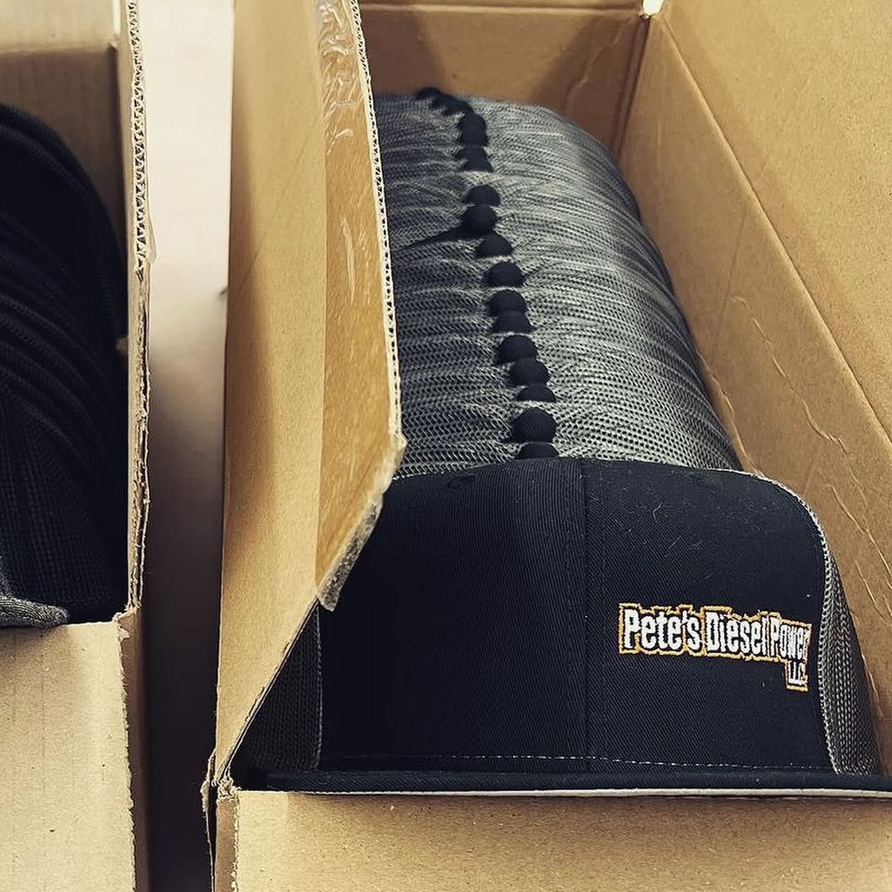 a stack of peter 's diesel hats in a cardboard box