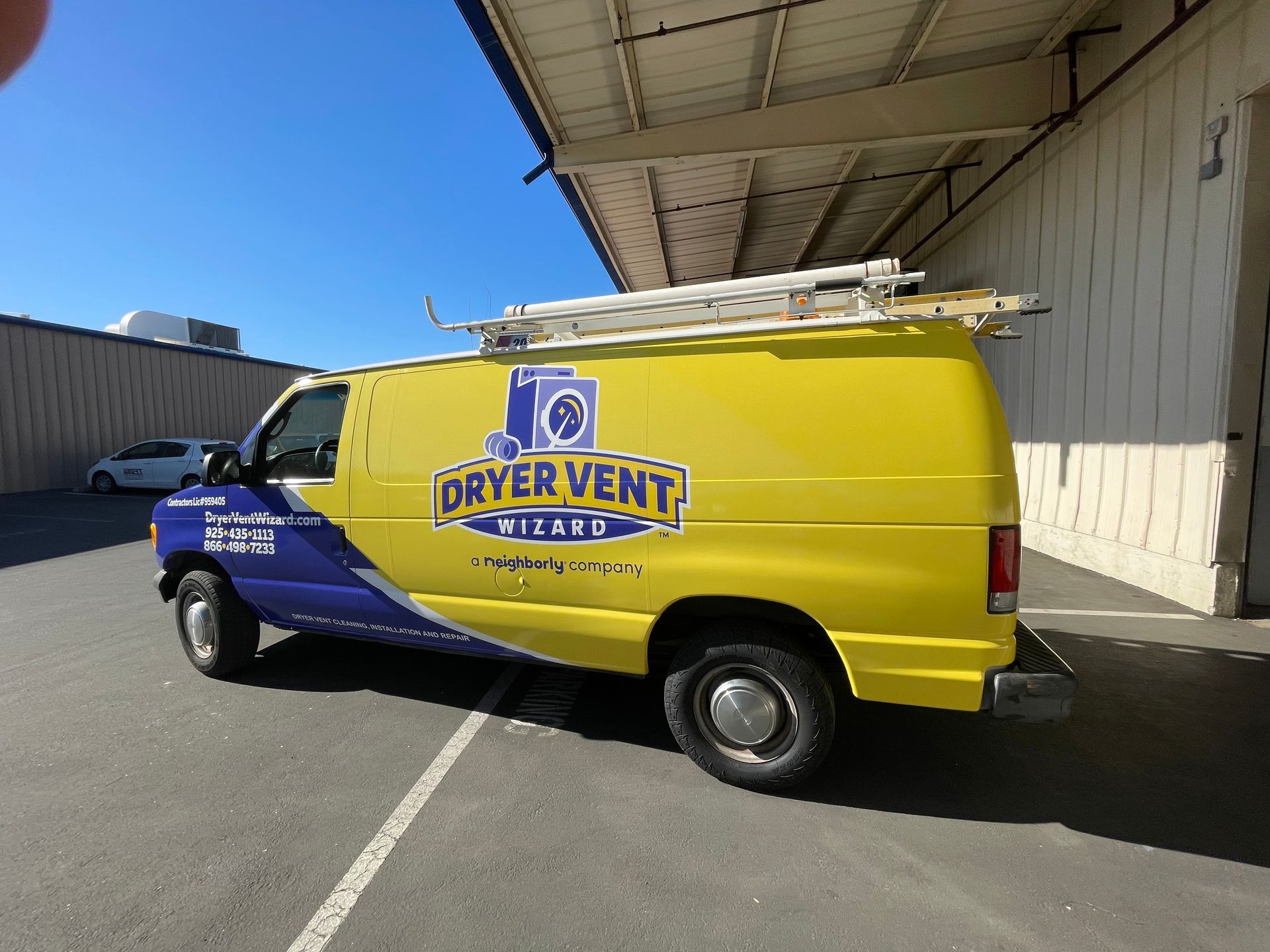 a yellow and purple dryer vent van is parked in a parking lot