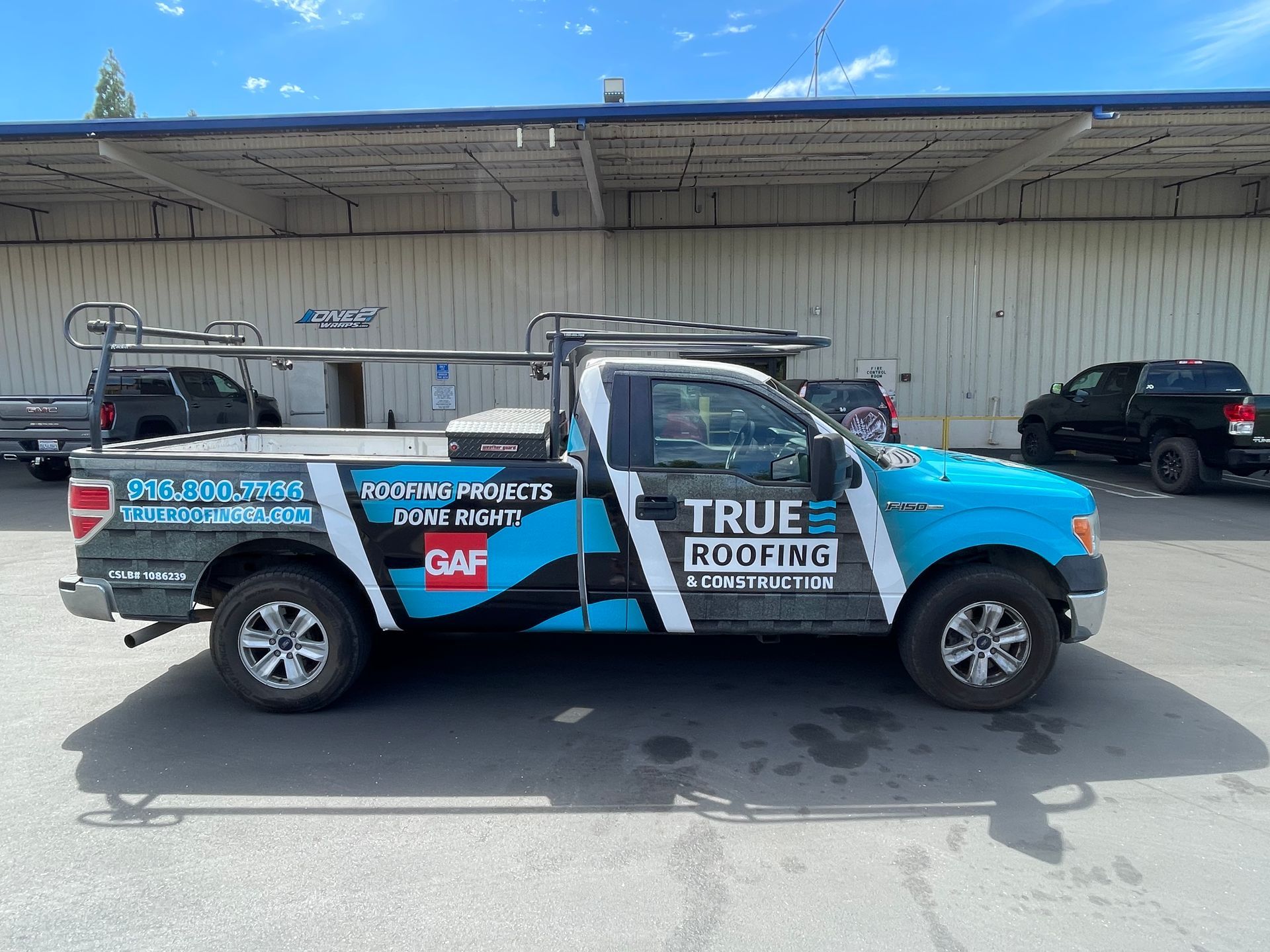 a blue and white truck is parked in front of a building .