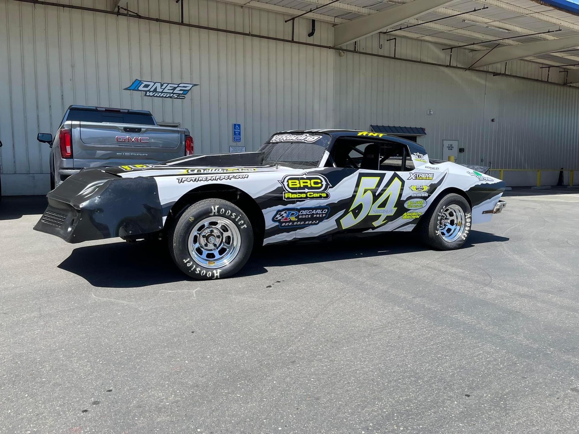 a race car is parked in front of a building .