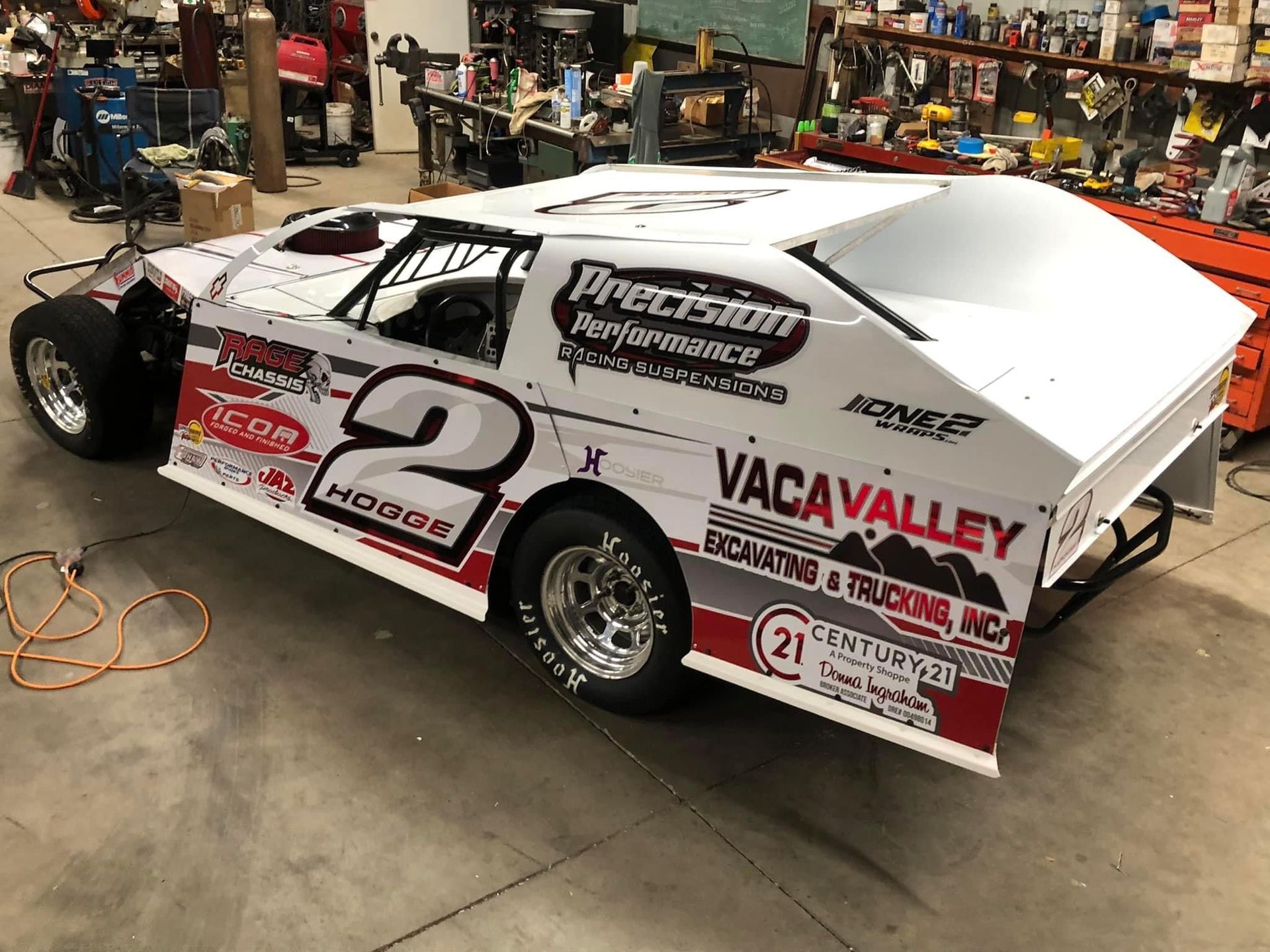 a race car with the number 2 on it is parked in a garage .