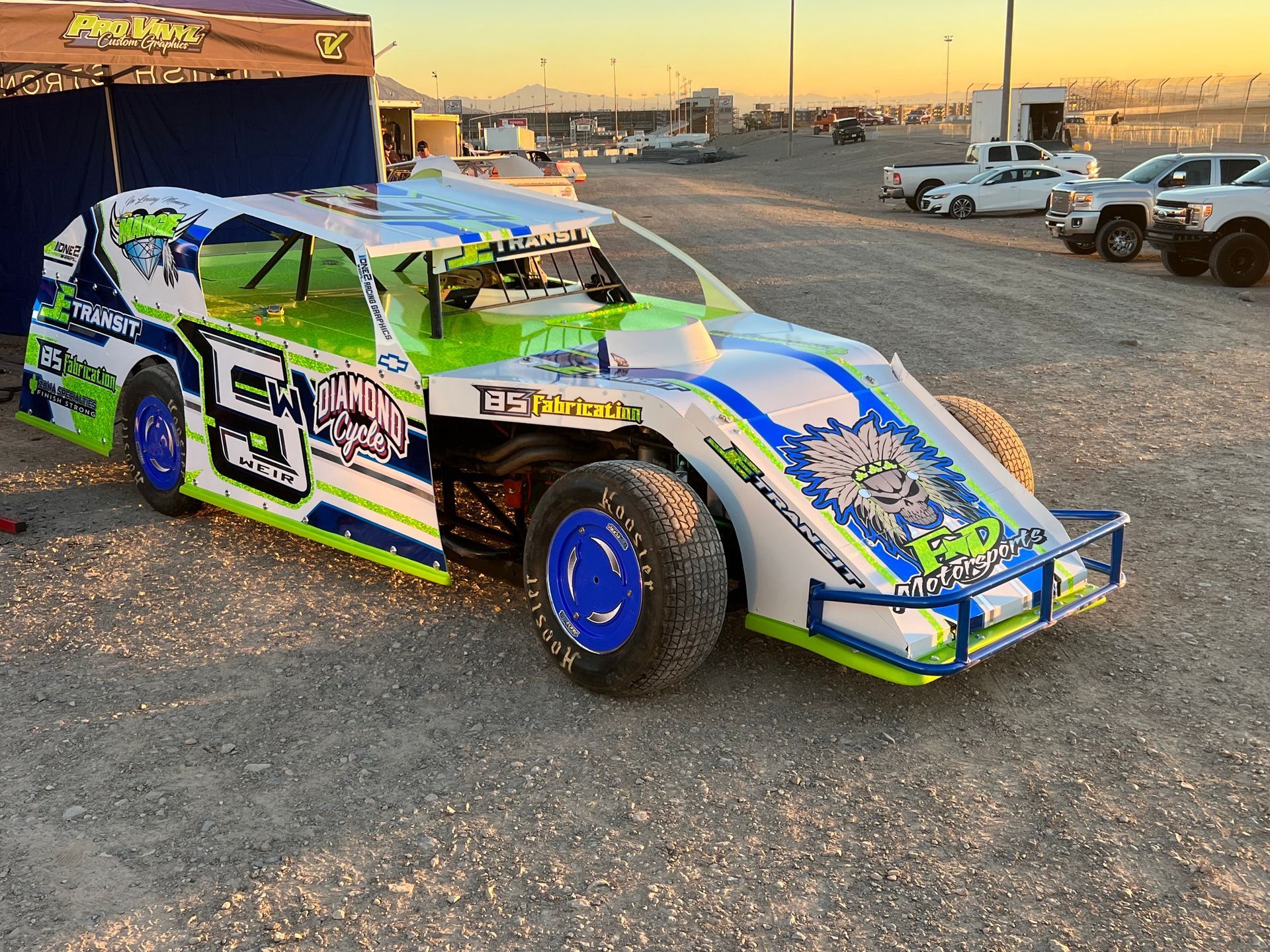 a race car is parked in a gravel lot .