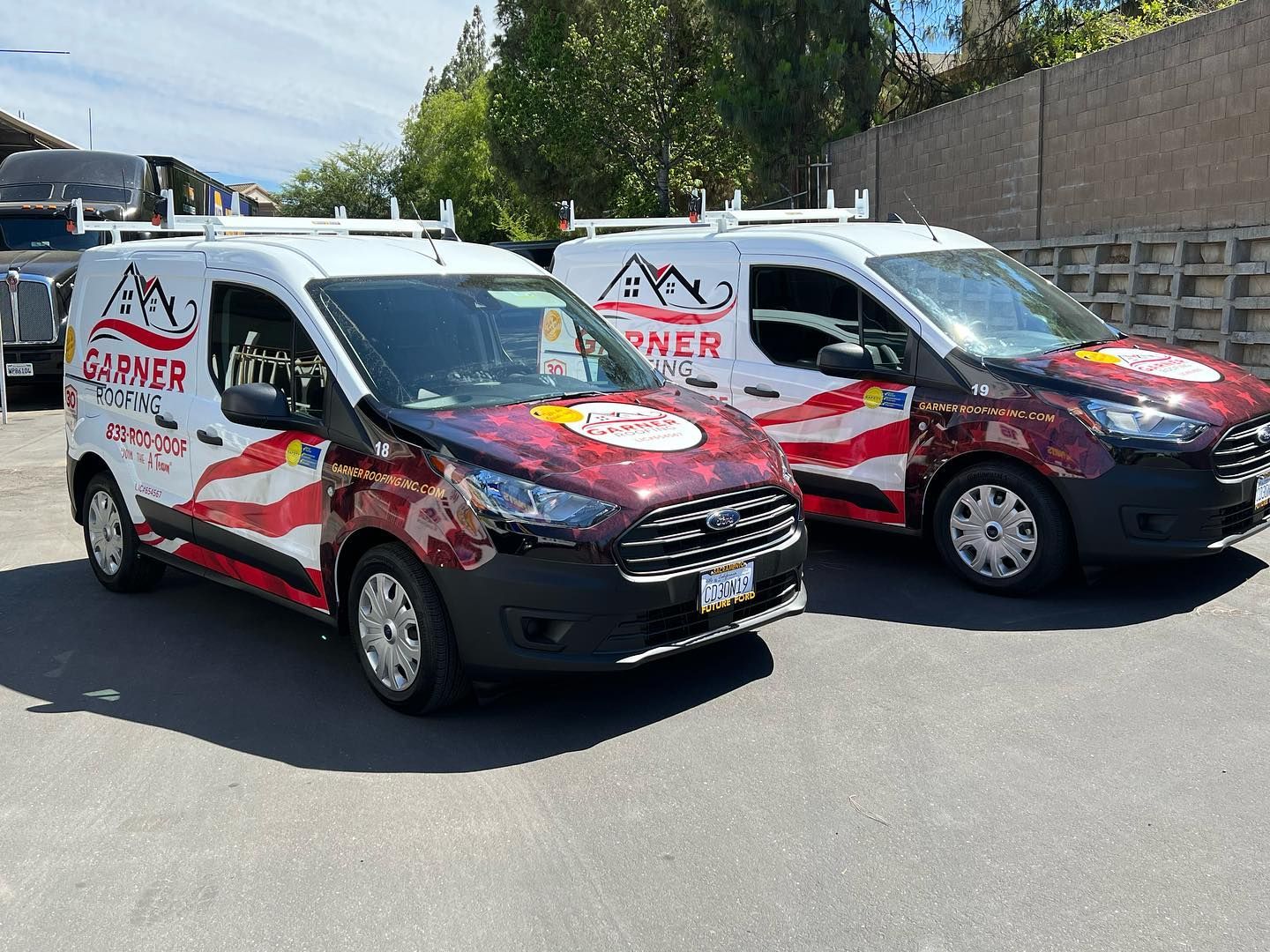 two vans are parked next to each other on the side of the road .