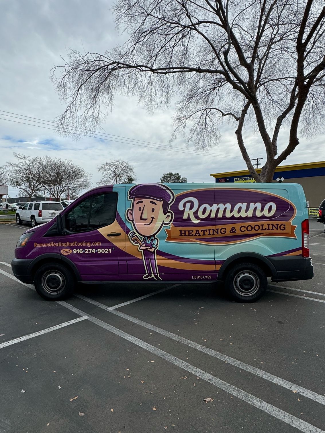 a purple and blue van is parked in a parking lot .