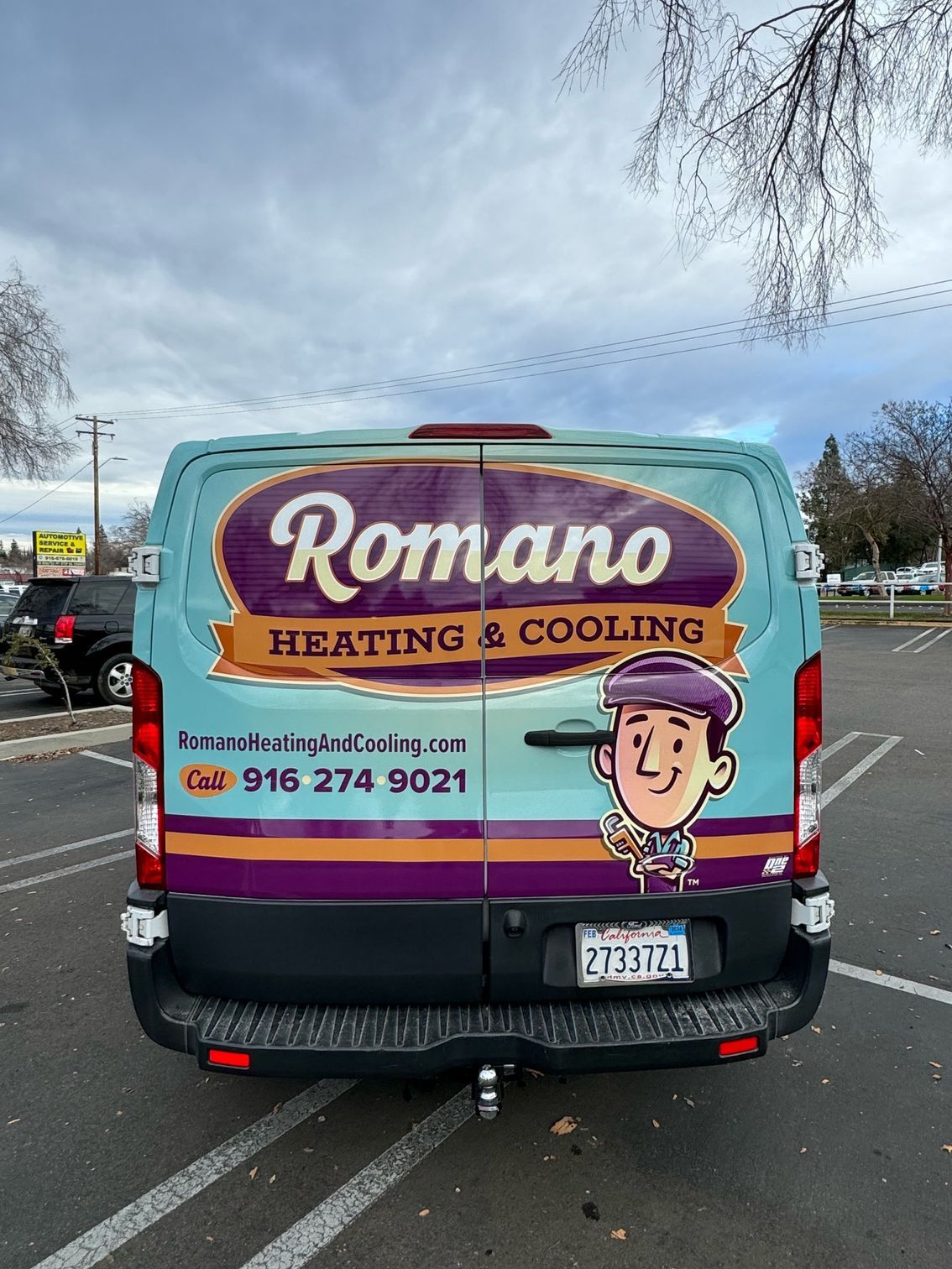 a romano heating and cooling van is parked in a parking lot .