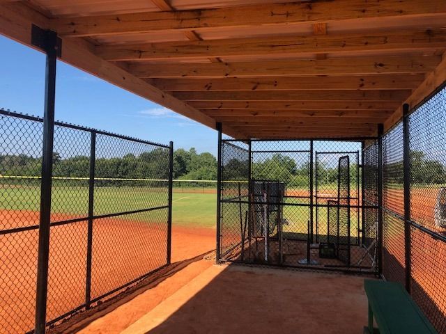 A baseball dugout with a chain link fence around it