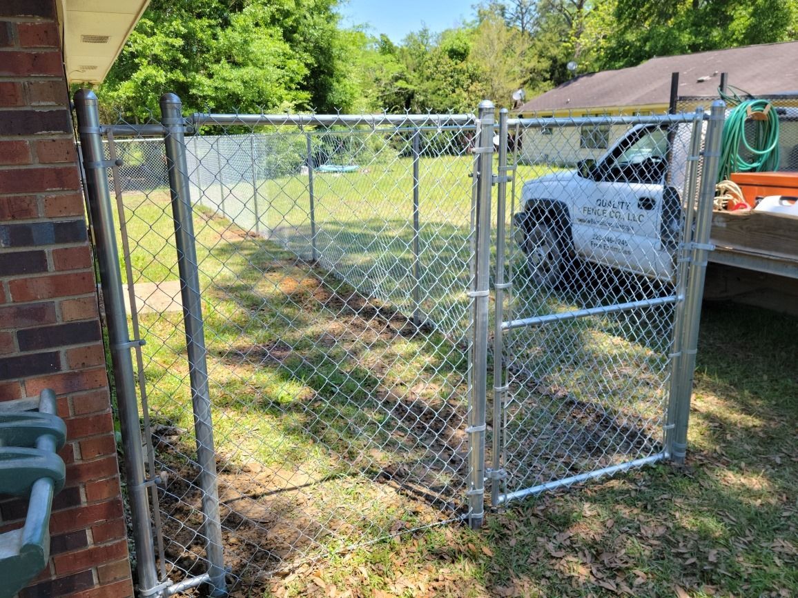 A chain link fence with a truck parked behind it.