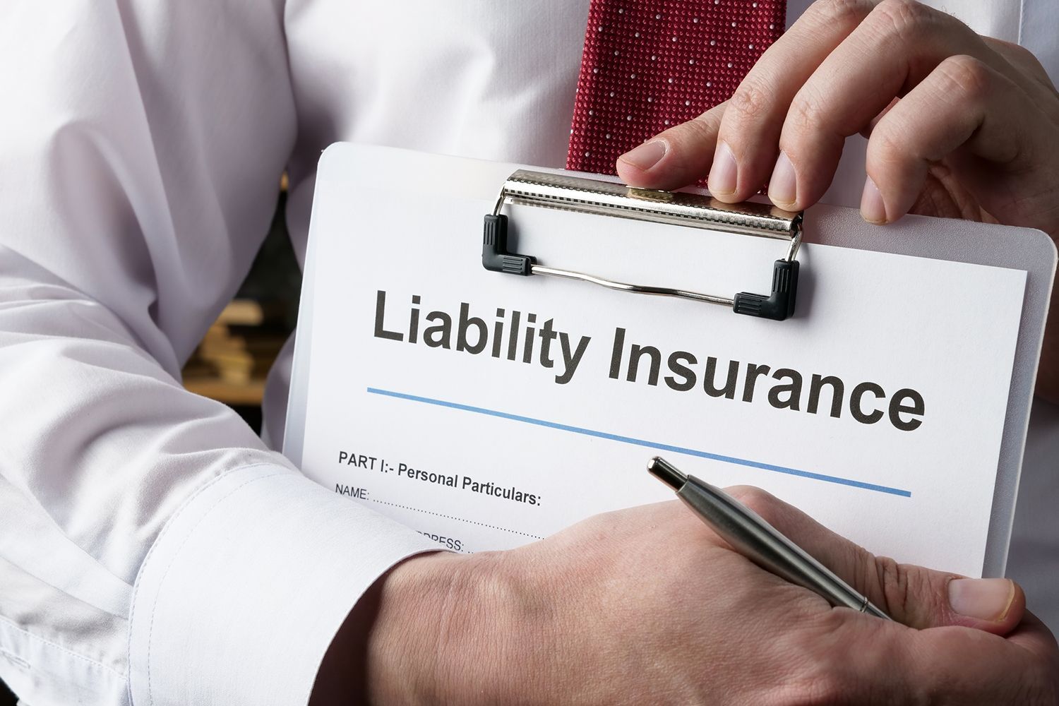 Person holding a clipboard with  Liability Insurance