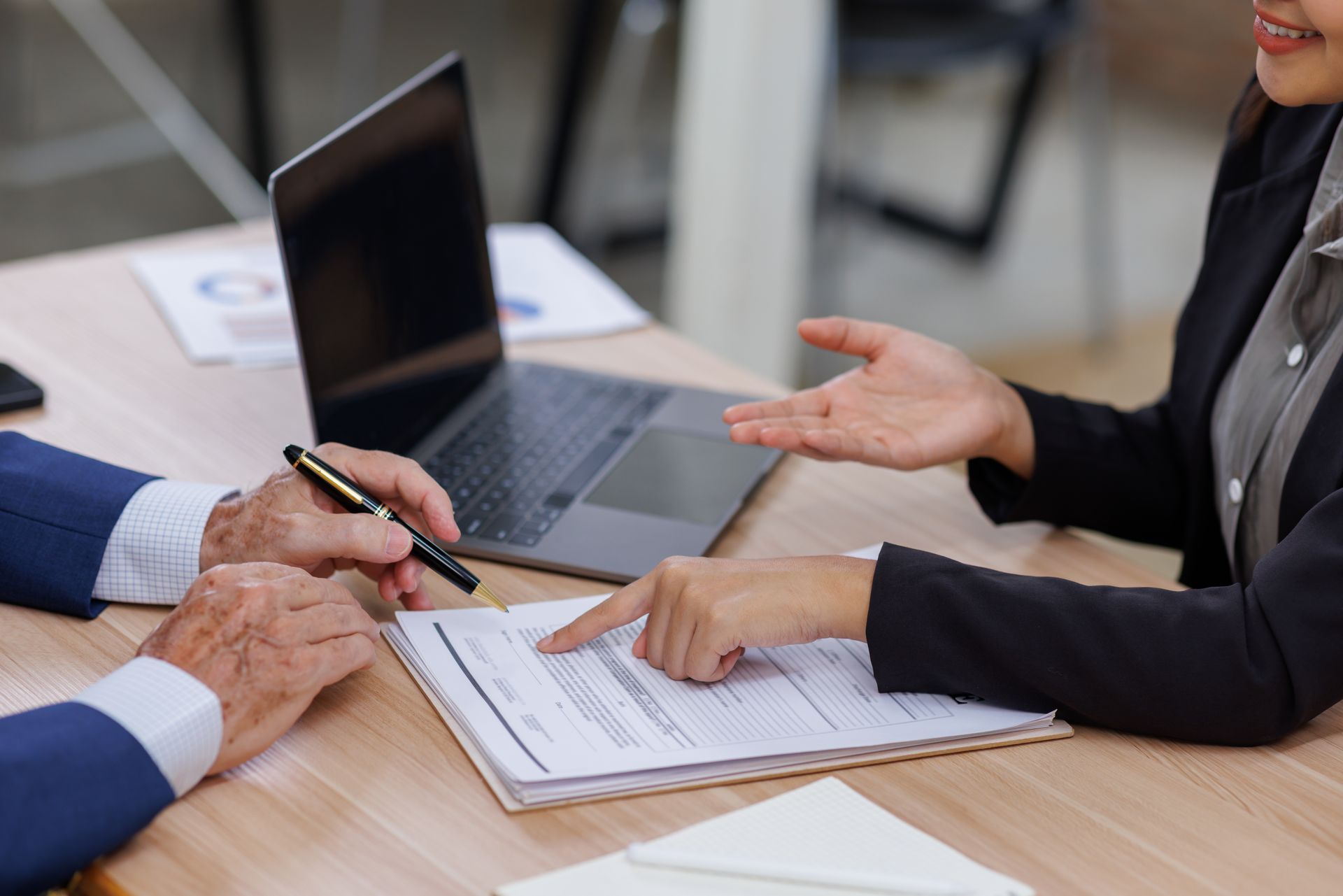 Two people shaking hands over a contract and a model house. Two people shaking hands over a contract and a model house.