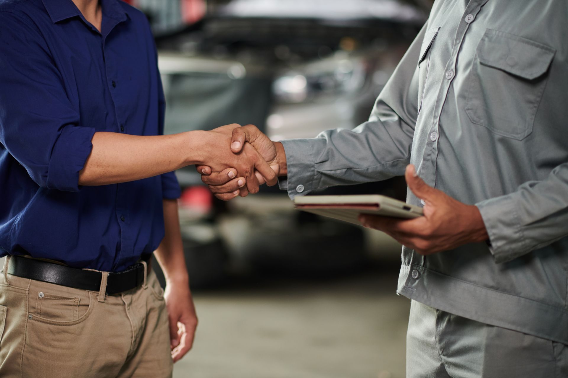 Woman on crutches shakes hands with another person, with others nearby.