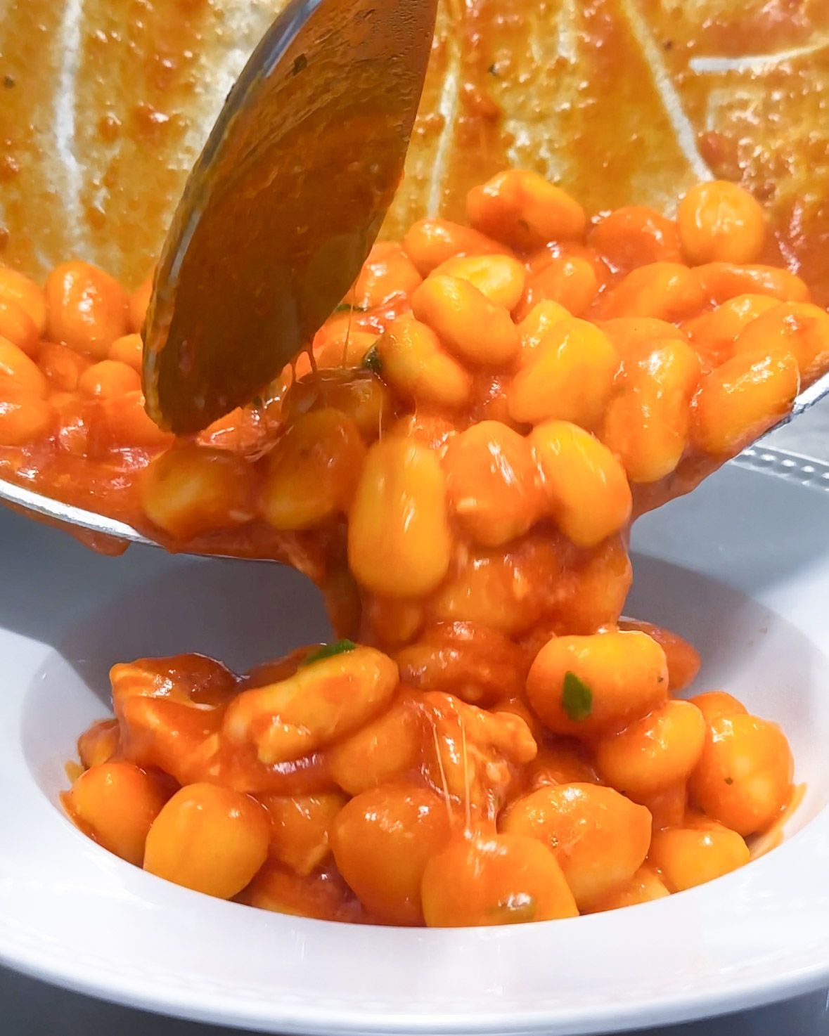 Gnocchi al sugo di pomodoro serviti in padella in una ciotola bianca.