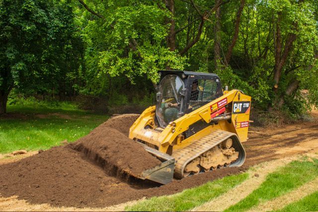 A bulldozer is cutting down trees in the woods.