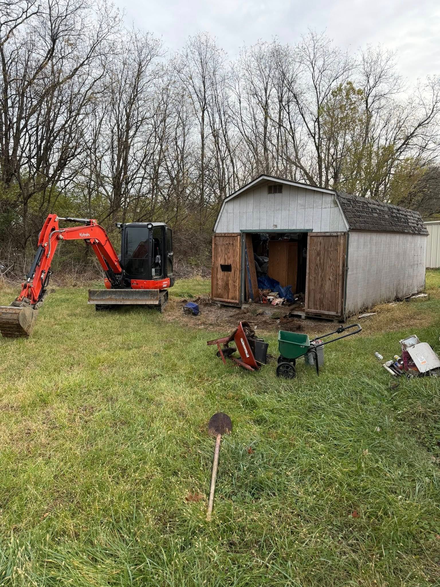 A bulldozer is demolishing a building with a crane attached to it.