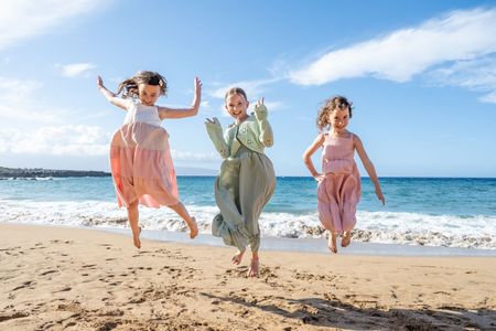 Woman in blazer and pink shirt smiles in front of mountain range.