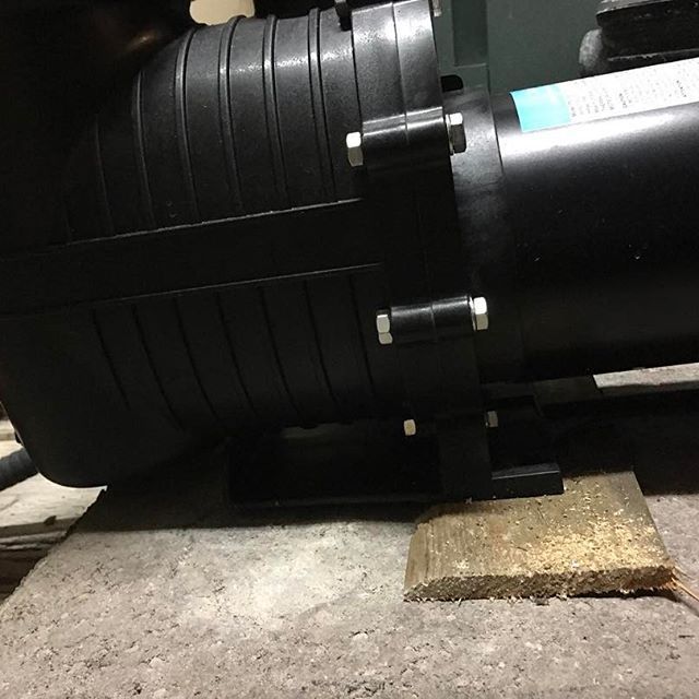 A black machine is sitting on a piece of wood