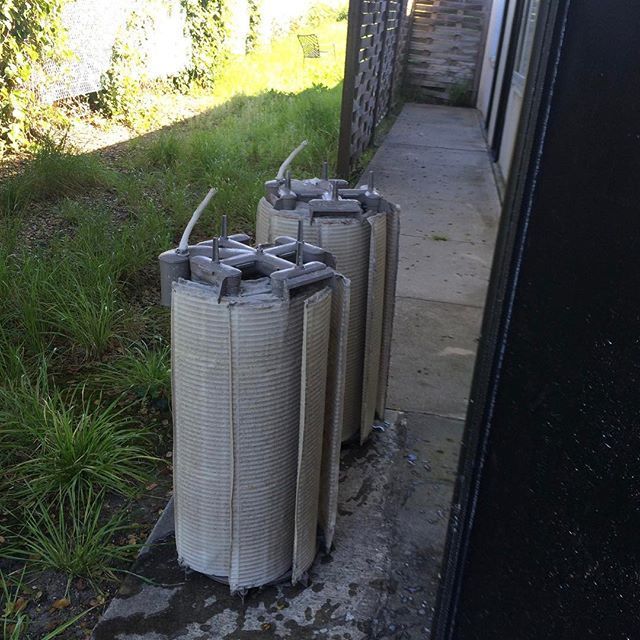 Two rolls of candles are sitting on a sidewalk next to a building.