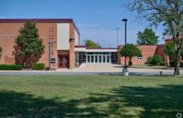 Broad Run Brick school building with central entrance, lawn in front, and trees under a clear blue sky