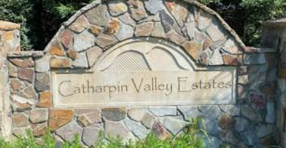 A stone monument sign reading Catharpin Valley Estates framed by an arched top and greenery. A stone monument sign reading Catharpin Valley Estates framed by an arched top and greenery.