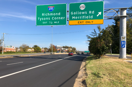 Highway overhead signs indicating exits for I-495 Richmond/Tysons Corner and Gallows Rd/Merrifield on a sunny day. Highway overhead signs indicating exits for I-495 Richmond/Tysons Corner and Gallows Rd/Merrifield on a sunny day.
