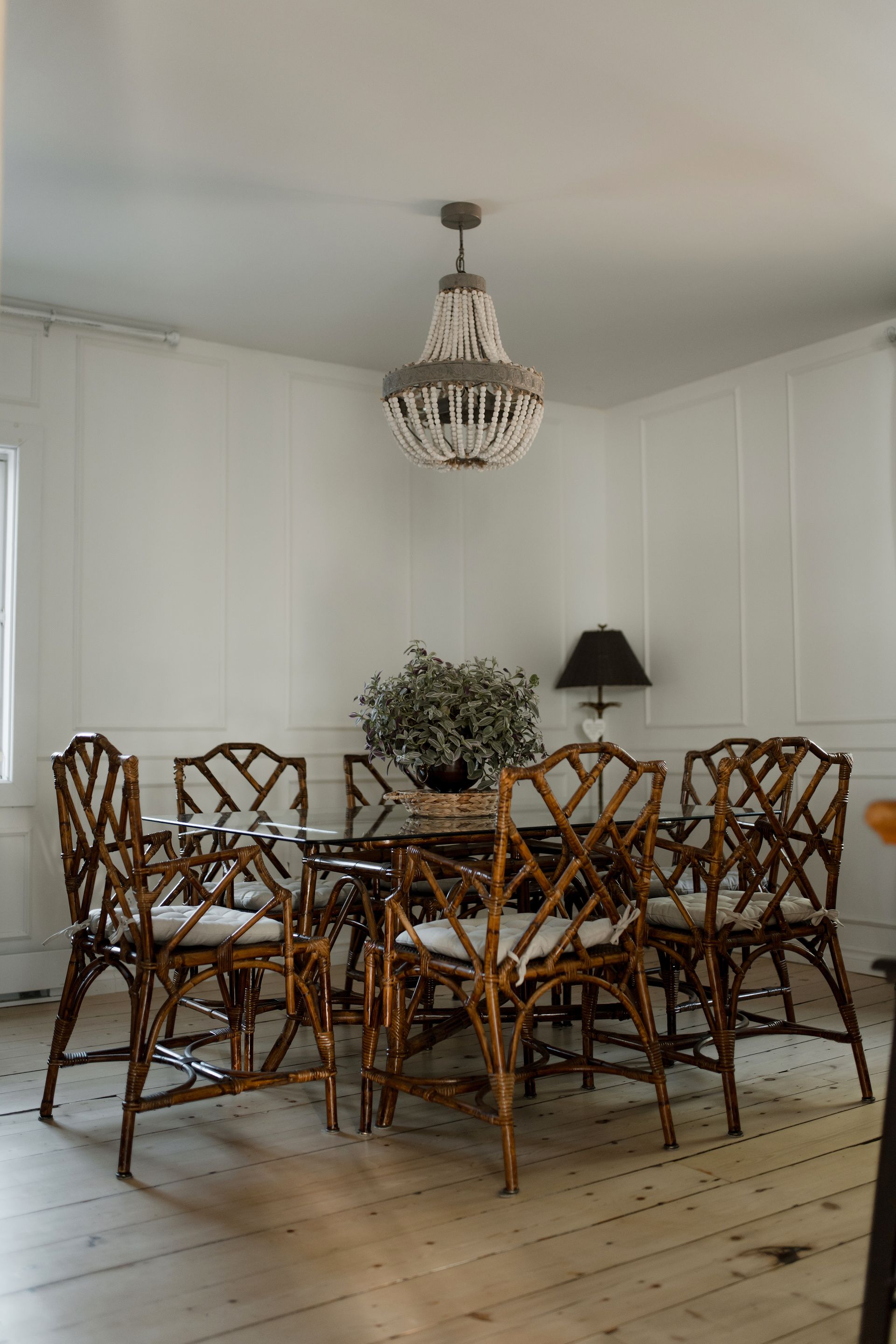 Chambre avec lit, tables de chevet, lampes et banc au pied. Œuvre d'art au mur.