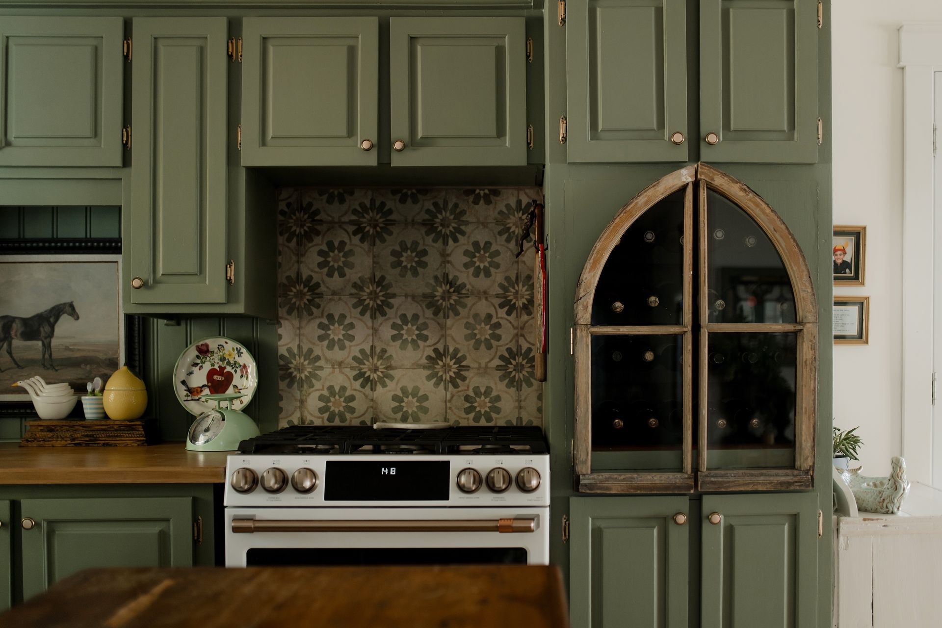 Salon avec vue sur un lac. Canapé jaune, parquet, table ronde noire et lustre.