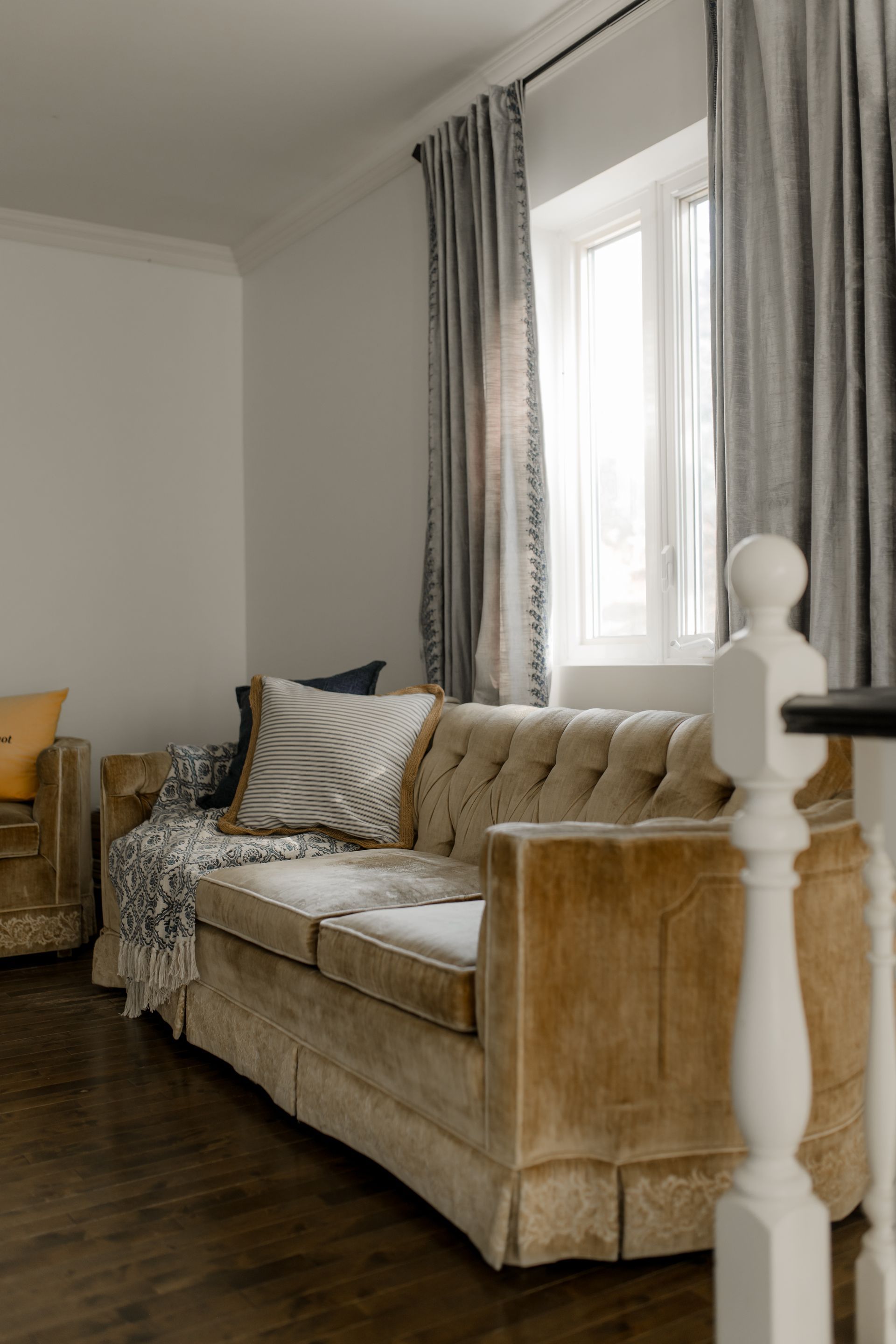 Salle à manger avec une table en verre, des chaises en bambou et un lustre en perles.
